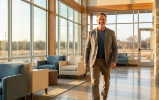 Patient walking confidently in a modern regenerative orthopedics San Antonio clinic lobby