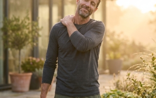 Man stretching shoulder outdoors, illustrating how to heal a torn rotator cuff naturally