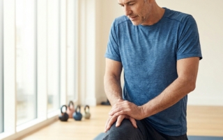 Man pausing during a knee pain workout to check his body before continuing training